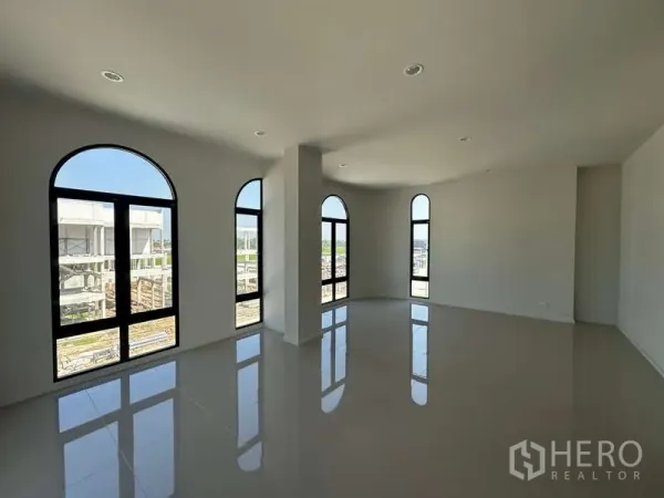 Factory for sale in Lam Luk Ka, Pathum Thani - Corner office room with multiple arched windows providing natural light and tiled flooring.