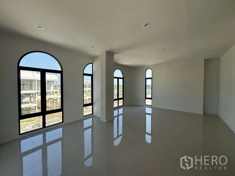 Factory for sale in Lam Luk Ka, Pathum Thani - Corner office room with multiple arched windows providing natural light and tiled flooring.