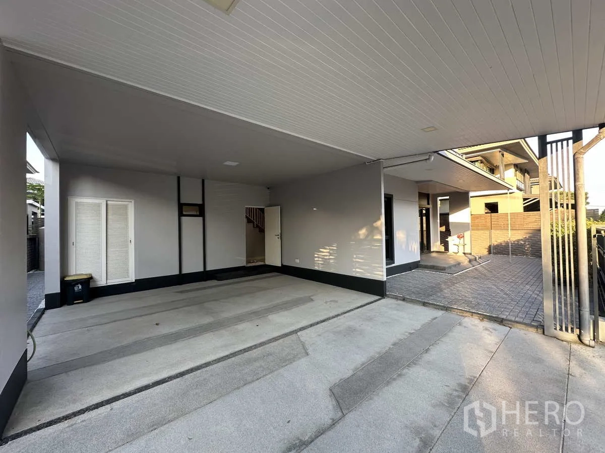 Detached House for rent or sale in Lam Luk Ka, Pathum Thani - Covered two‑car carport and front porch with built‑in storage at the entrance.