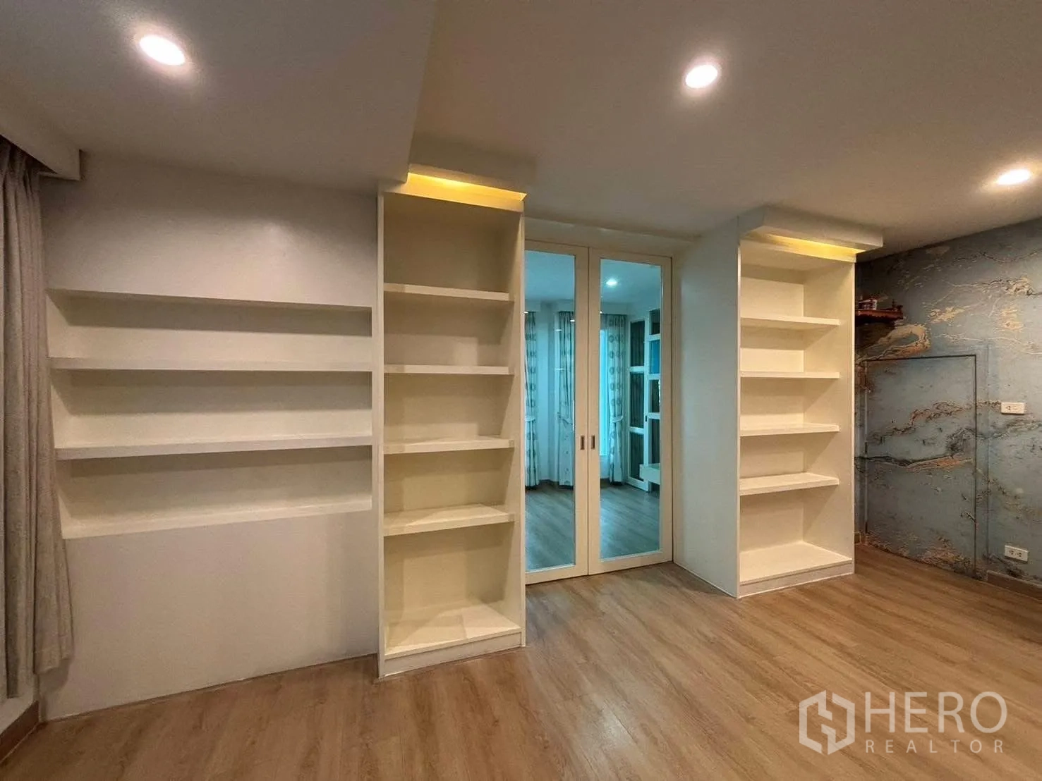 Detached House for rent in Bang Kapi, Bangkok - Built-in white shelving with mirrored sliding doors in multipurpose room.