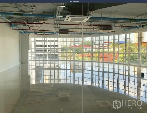 Office Space for rent in Khlong Toei, Bangkok - Corner workspace with panoramic glass facade and city and greenery views across large windows.