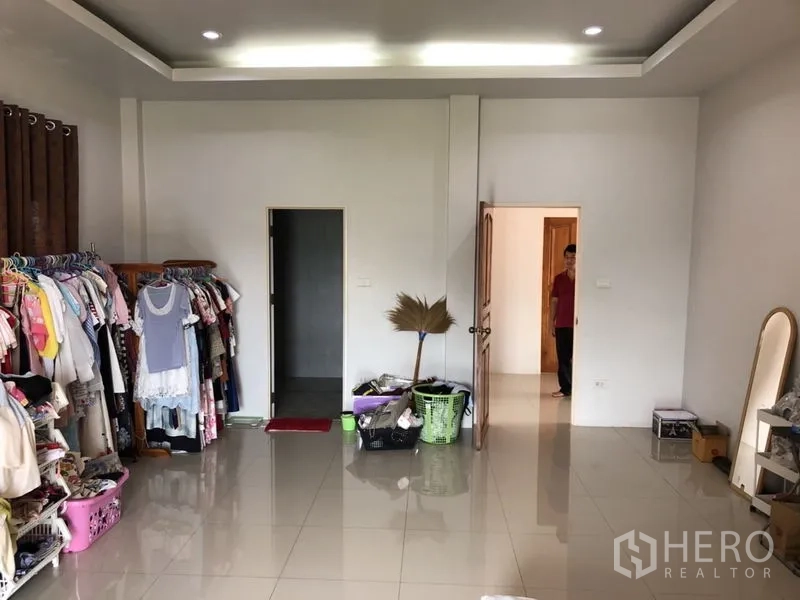 Detached House for sale in Lam Luk Ka, Pathum Thani - Dressing area with clothing racks inside a large bedroom.