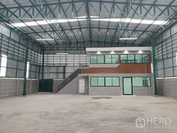 Warehouse for rent in Prawet, Bangkok - Spacious warehouse interior with steel roof trusses and a two-storey glass-front office.