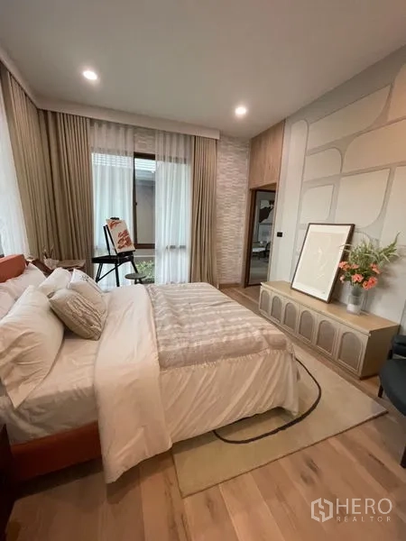 Detached House for sale in Bang Kapi, Bangkok - Guest bedroom in warm neutral tones with sheer drapes and a built-in console.
