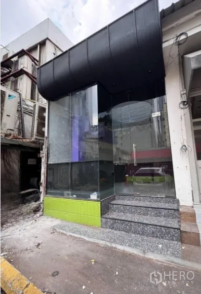 Retail Space for rent in Watthana, Bangkok - Street-facing corner retail frontage with full-height glass, black awning, and terrazzo steps.