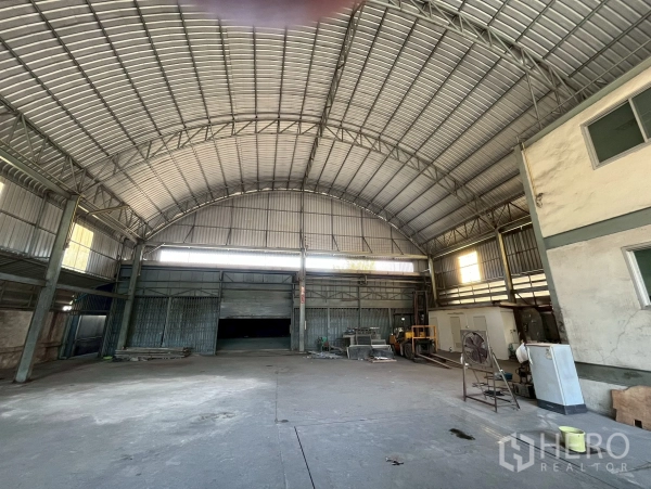 Factory for rent in Phra Pradaeng, Samut Prakan - Main loading area with multiple roller shutter doors and equipment zone.
