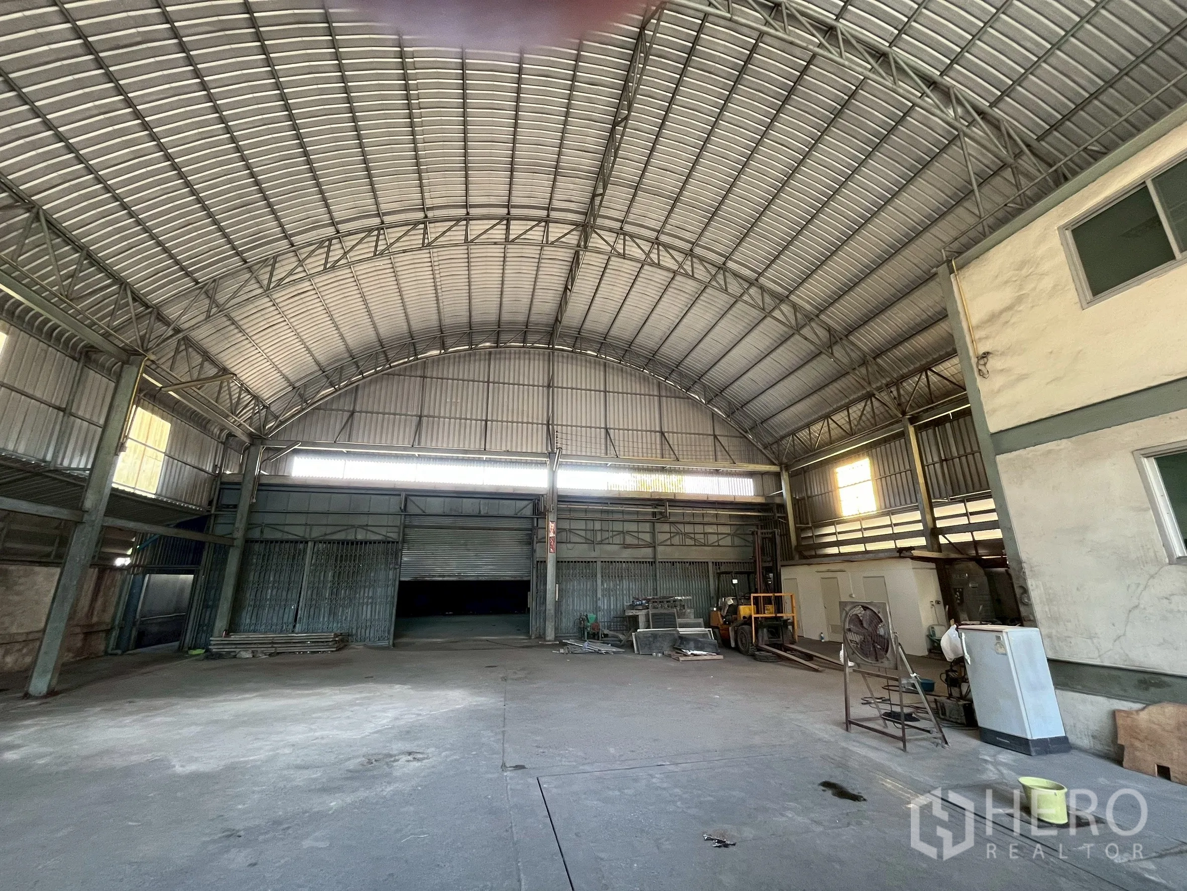 Factory for rent in Phra Pradaeng, Samut Prakan - Main loading area with multiple roller shutter doors and equipment zone.