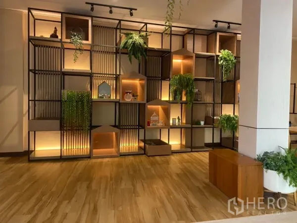 Retail Space for rent in Khlong Toei, Bangkok - Feature wall of illuminated modular shelving with plants and decor in a wood-floored retail area.
