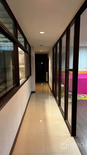 Factory for rent or sale in Pathum Thani - Interior corridor with glass partitions and tiled floor linking office areas.