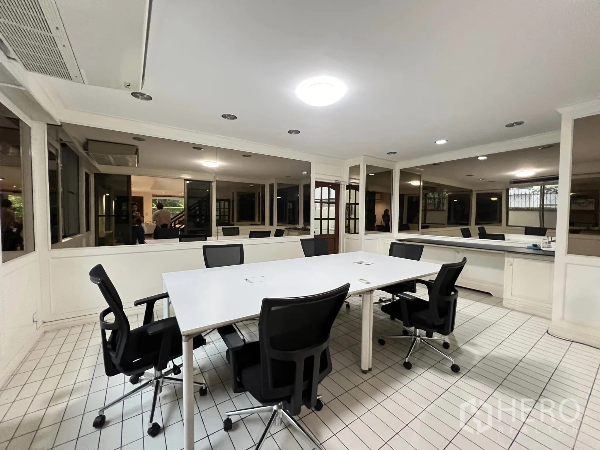 Townhouse for rent in Watthana, Bangkok - Bright meeting room with tiled floor, white conference table and black chairs.