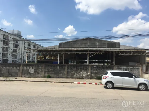 货栈 出租在Khlong Luang, Pathum Thani - 面向街道的仓库外观，带围墙与大门，卡车进出便捷，位于空銮。