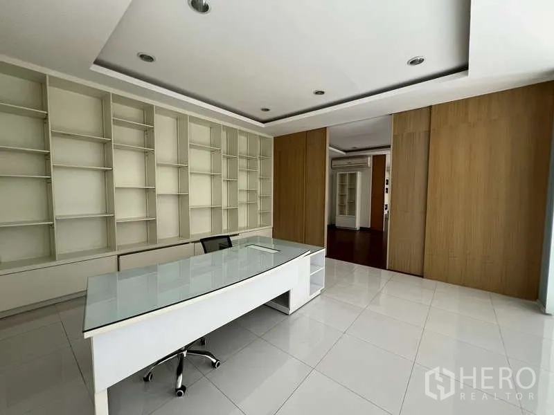 Showroom for rent - Executive office fitted with built-in shelving and a glass-top desk.