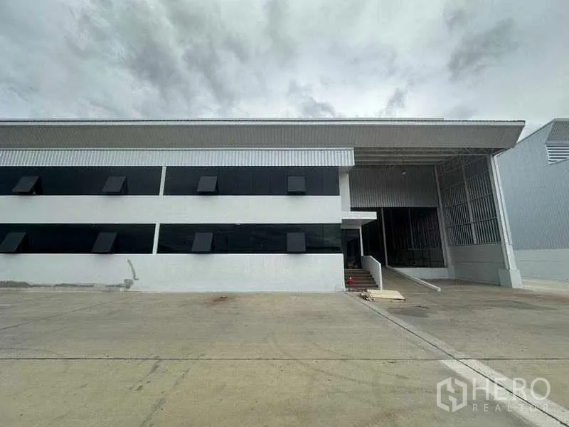 Factory for rent in Wang Noi, Phra Nakhon Si Ayutthaya - Front elevation of the industrial building showing canopy roof and truck access ramp.