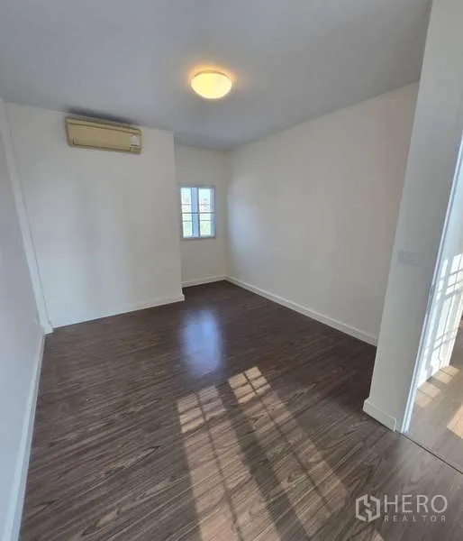 Townhouse for sale in Watthana, Bangkok - Sunlit multipurpose room with wood floors, small windows and air conditioning.