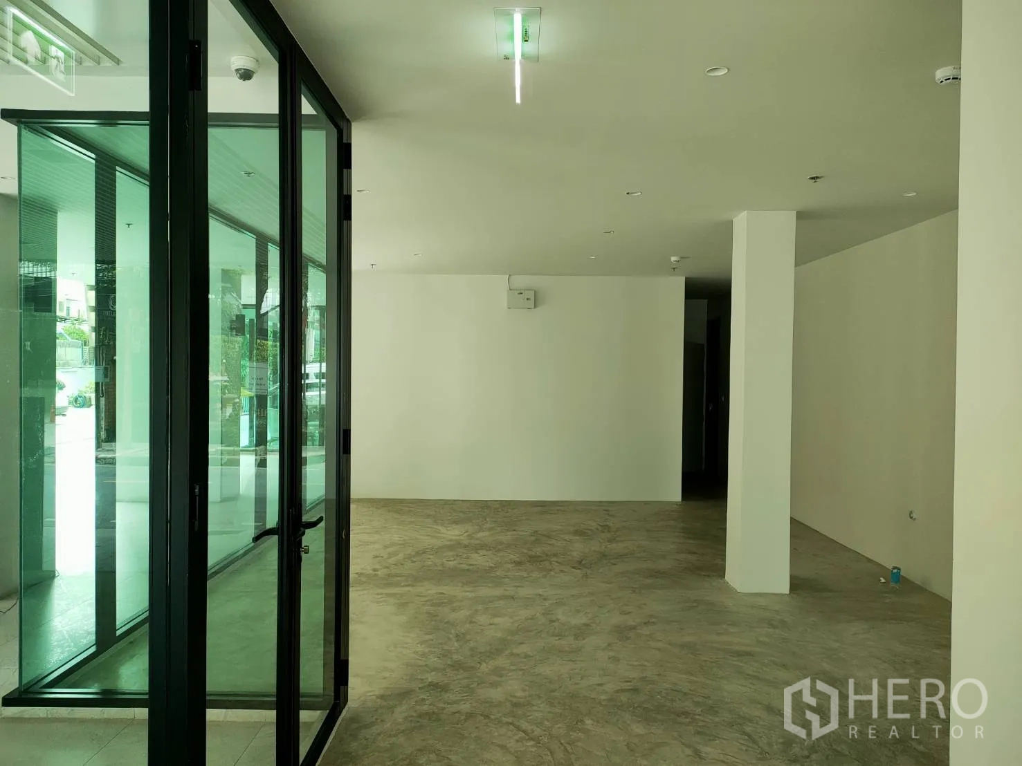 Retail Space for rent in Khlong Toei, Bangkok - Open-plan shop space with glass entrance doors, ceiling lights and a central column.