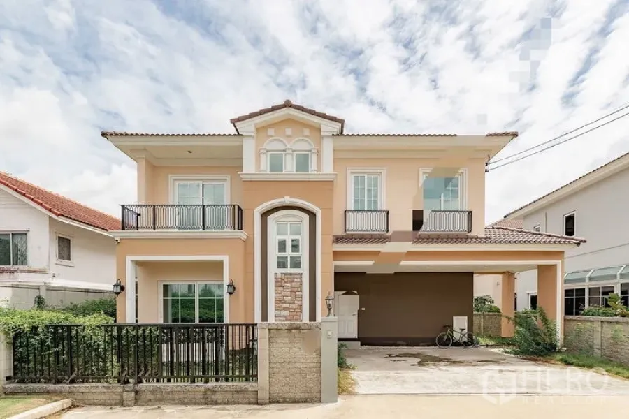 Detached House for rent or sale in Bang Khen, Bangkok - Two-storey detached house exterior with balconies, gated driveway and covered parking.