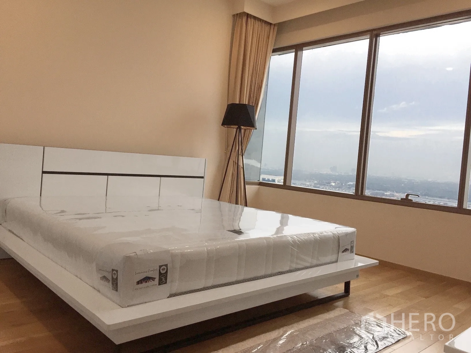 Condominium for rent or sale in Khlong Toei, Bangkok - Spacious bedroom with large windows, hardwood floor and skyline views.