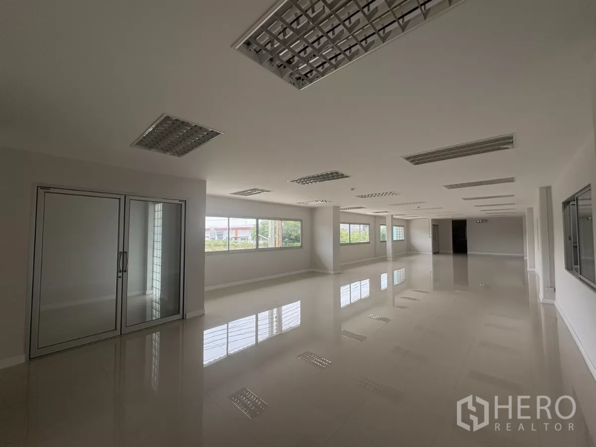 Factory for rent in Bang Phli, Samut Prakan - Large office workspace with windows and ceiling fluorescent lights.