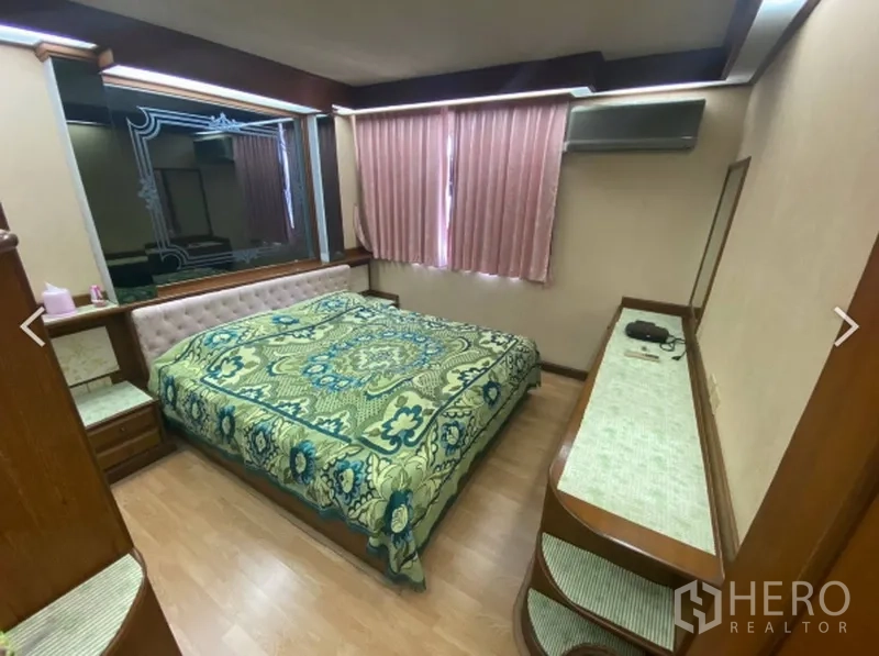 Condominium for sale in Watthana, Bangkok - Master bedroom with king bed, window blinds, air conditioner and dressing console at D.S. Tower 2.