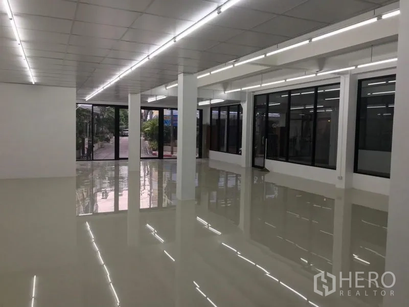Office Space for rent in Chatuchak, Bangkok - Bright open-plan office with glossy tile floors, LED strip lighting and floor-to-ceiling glass at the entrance.