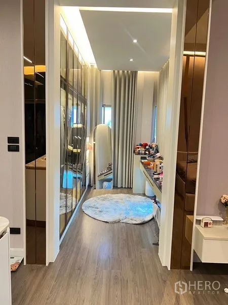 Detached House for sale in Bang Kapi, Bangkok - Walk-in closet hallway with mirrored wardrobes and a makeup desk.