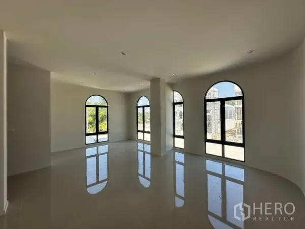 Factory for sale in Lam Luk Ka, Pathum Thani - Bright upper-floor office with glossy tiles and tall arched black-framed windows.