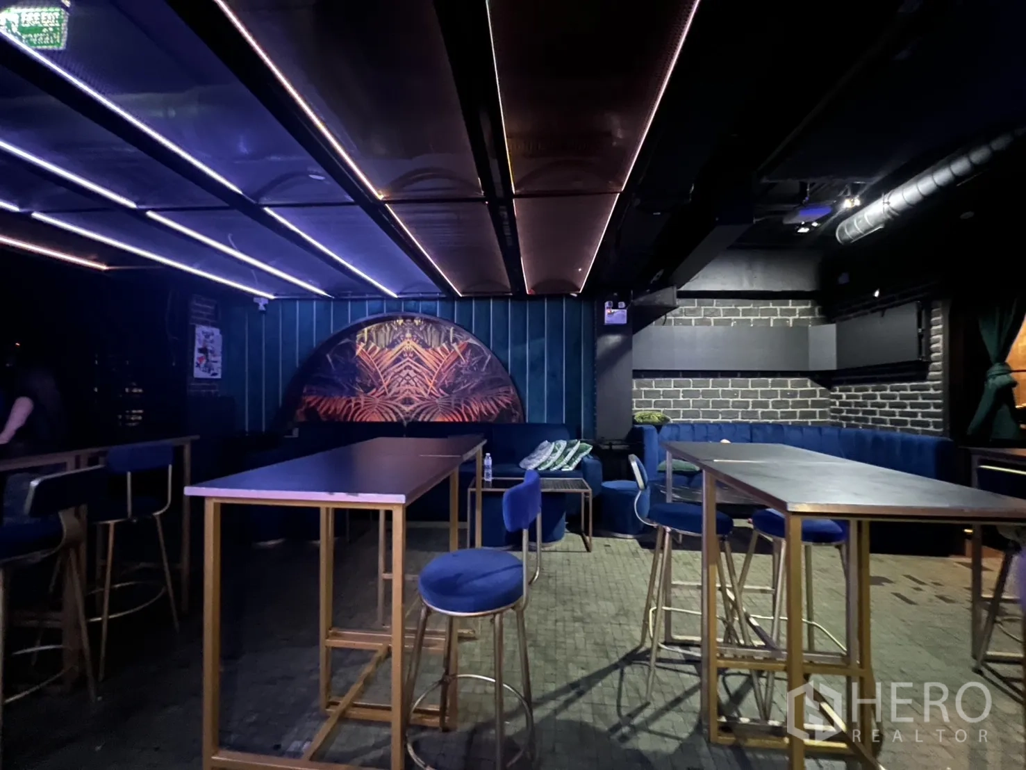 Retail Space for rent in Bangkok - High tables area with blue stools and ceiling light panels.