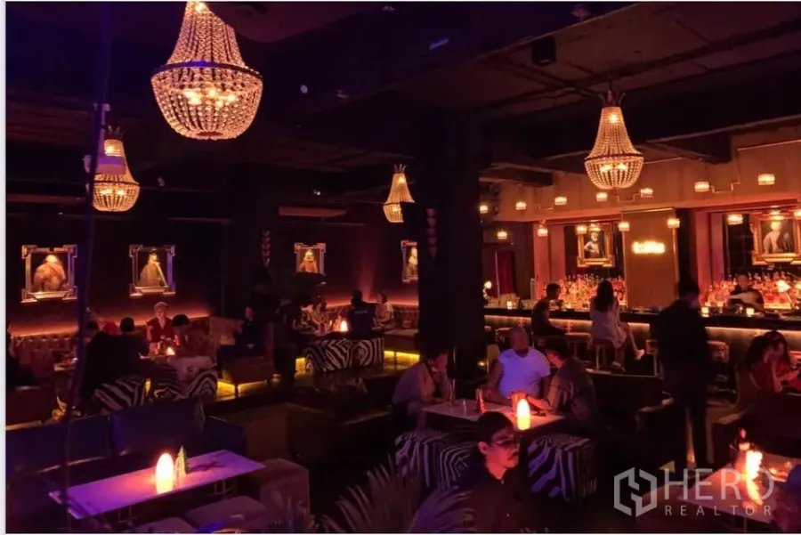 พื้นที่ขายปลีก ให้เช่าในWatthana, Bangkok - เลาจน์ไฟสลัวพร้อมโคมระย้า โต๊ะสีขาว และที่นั่งลายม้าลาย