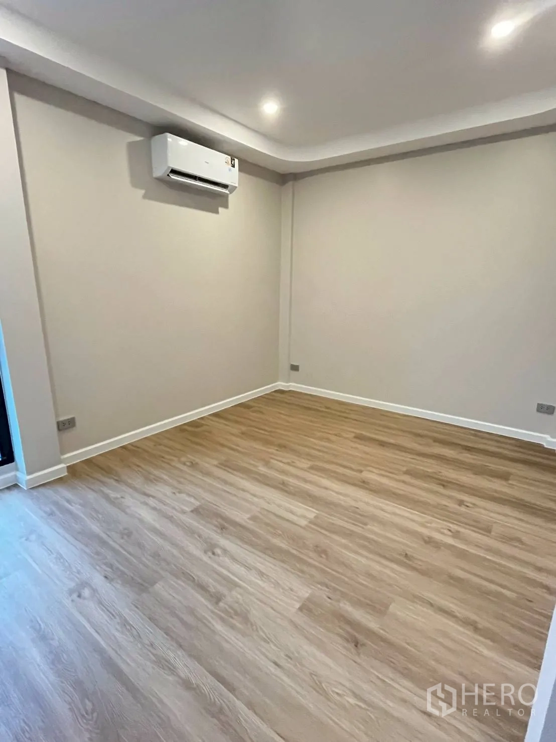 Townhouse for rent in Khlong Toei, Bangkok - Bedroom featuring wood floors and a wall-mounted air conditioner.