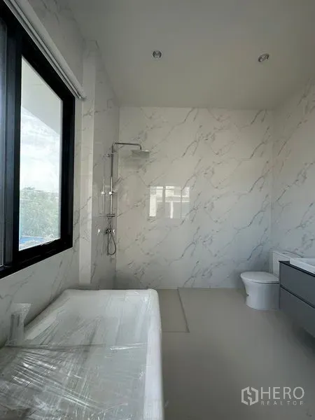 Detached House for rent in Watthana, Bangkok - Contemporary bathroom with marble-effect tiles, walk-in rain shower, bathtub, and vanity.