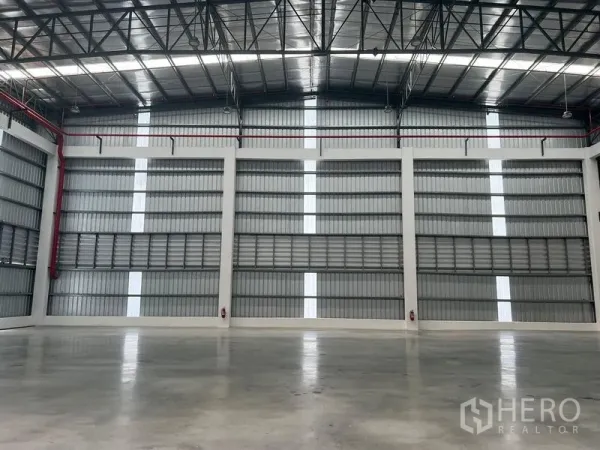Factory for rent in Bang Pakong, Chachoengsao - Clear-span production floor featuring insulated roof, louvered ventilation and multiple fire hose reels.