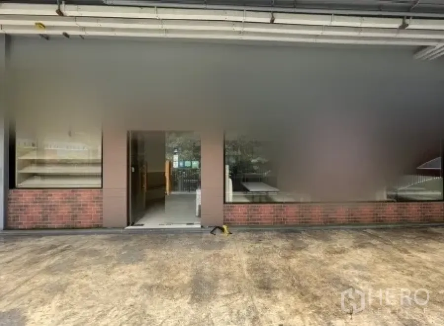 Retail Space for rent in Khlong Toei, Bangkok - Street-level shopfront with wide glass windows and a central entrance door.