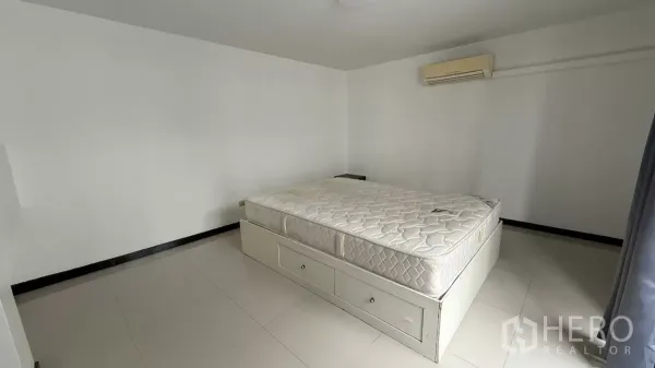 Home Office for rent in Bang Na, Bangkok - Bright bedroom with storage bed drawers, wall-mounted air conditioner and white ceramic tiles.