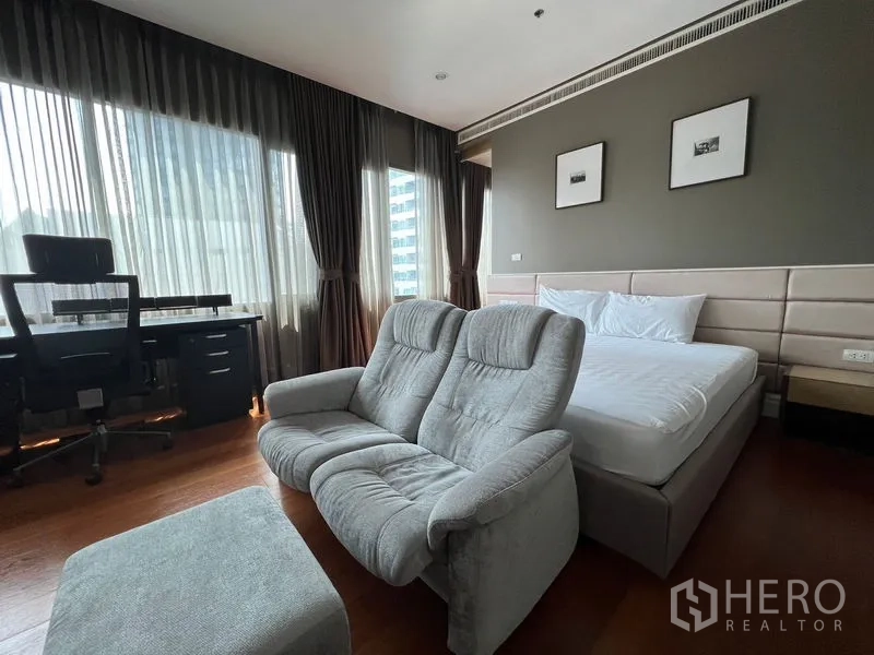 Condominium for rent in Khlong Toei, Bangkok - Master bedroom view showing bed, sofa, and abundant natural light.