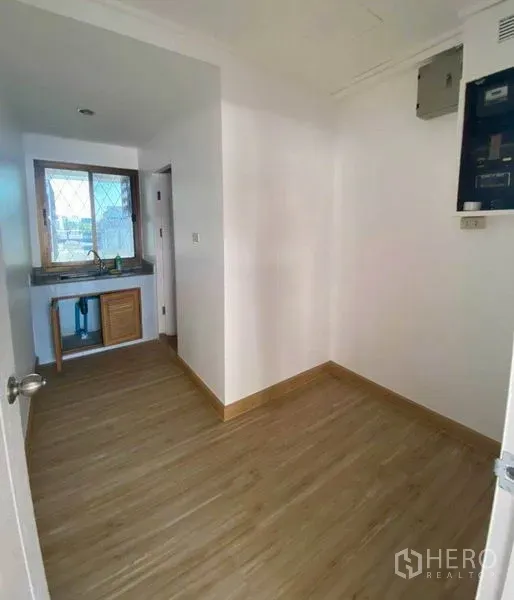 Office Space for rent in Watthana, Bangkok - Compact office pantry with sink and window beside a small utility room.