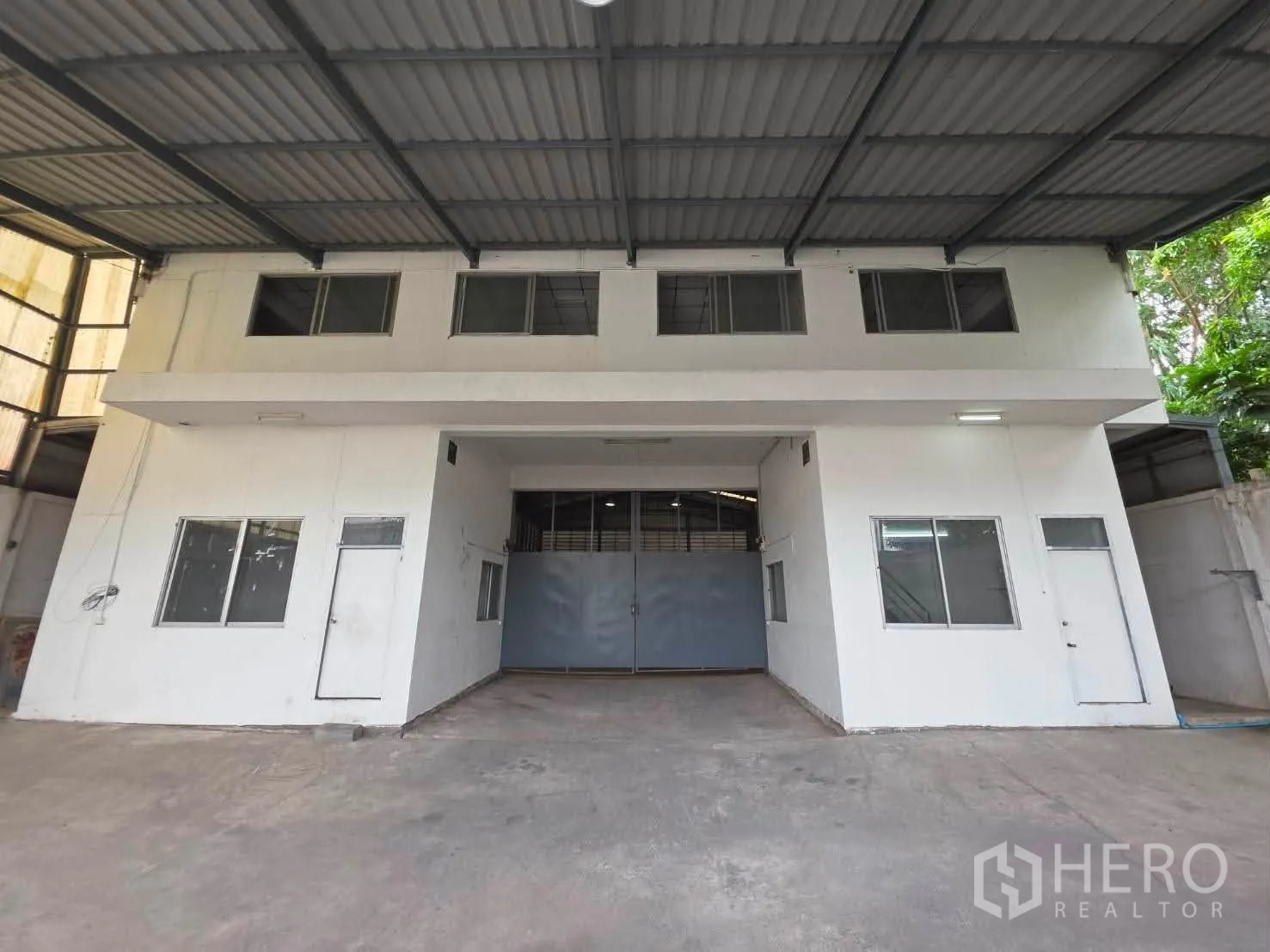 Warehouse for rent or sale in Phra Khanong, Bangkok - Front elevation of warehouse with covered canopy and central entry doors.