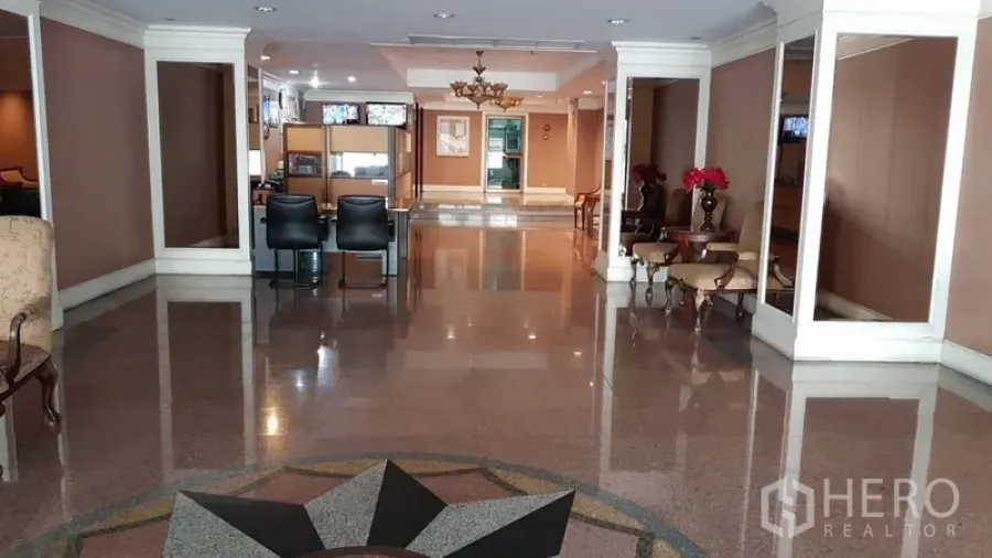 Condominium for rent in Watthana, Bangkok - Elegant condominium lobby with polished floors, chandeliers, and a staffed reception area.