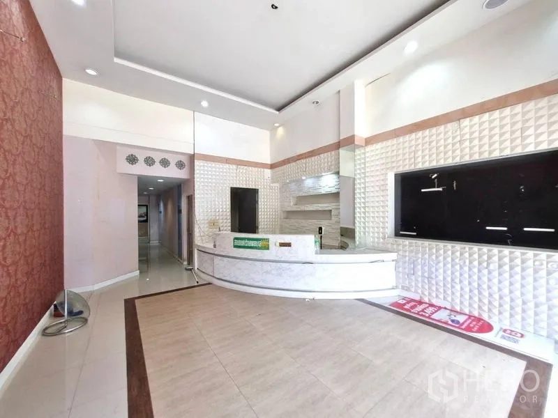 Shophouse for rent in Watthana, Bangkok - Ground‑floor lobby featuring a high ceiling and curved marble reception counter.