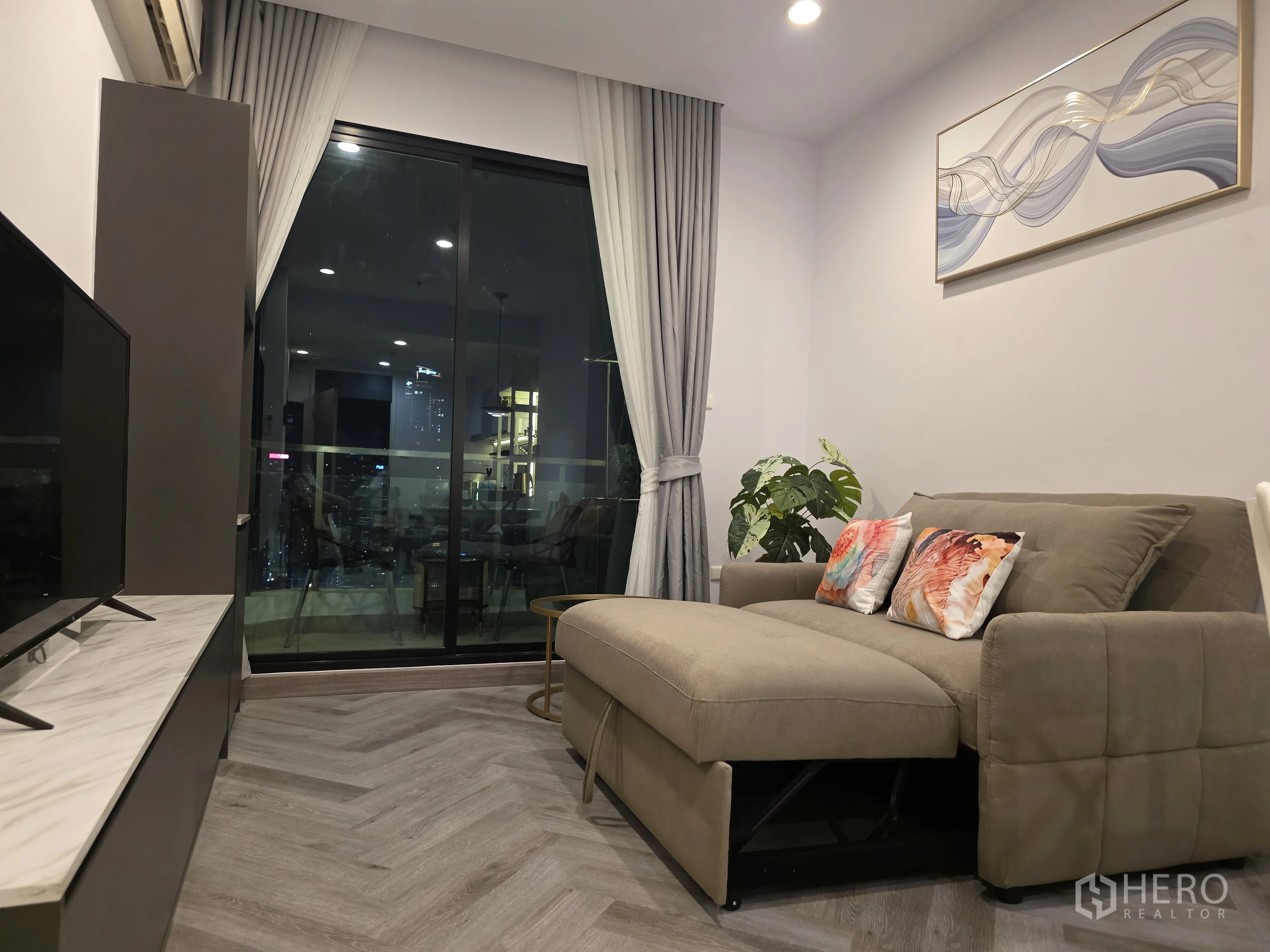 Condominium for rent in Bang Kapi, Bangkok - Kitchen with white cabinets, under-cabinet lighting, and dining set.