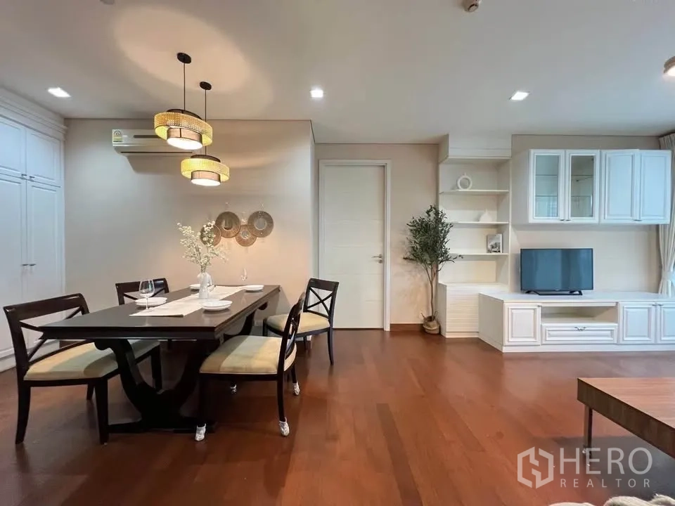 公寓 for rent in Watthana, Bangkok - 客餐厅一体空间，木地板、吊灯、内置电视柜与已摆放餐具的餐桌。