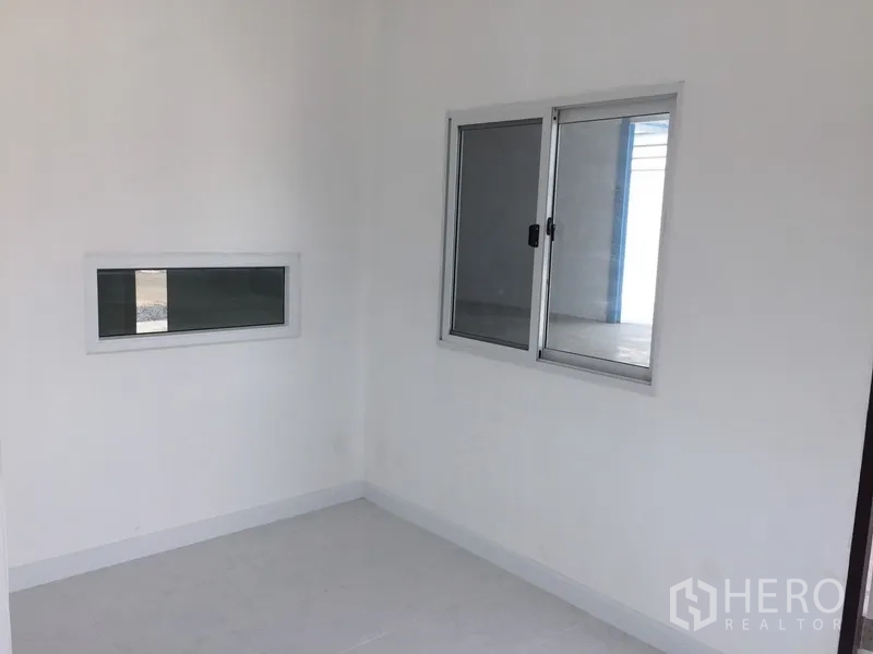 工厂 出租在Pathum Thani - 明亮小型办公室，白墙、浅色地面与铝合金推拉窗。