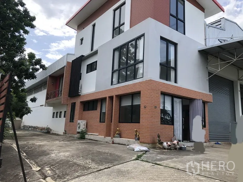 工厂 出租或出售在Lat Lum Kaeo, Pathum Thani - 厂房侧视，大片落地窗与砖立面，旁有卷闸门。