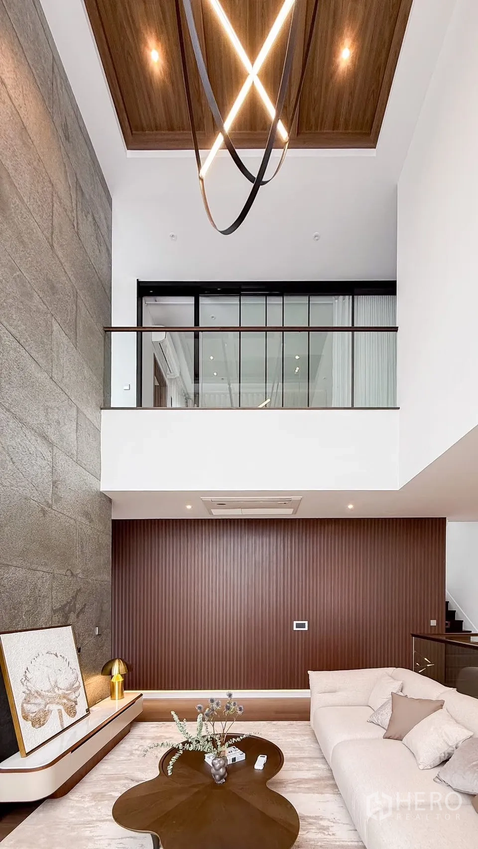 Detached House for rent or sale in Bang Kapi, Bangkok - Loft-style space with wood ceiling detail, glass railing and linear lighting.