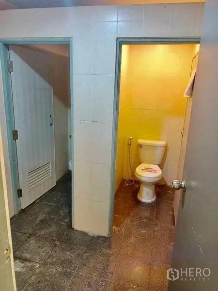 Warehouse for rent in Samut Prakan - Tiled restroom area with separate toilet cubicles inside the warehouse.