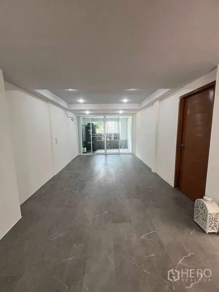 Townhouse for rent in Khlong Toei, Bangkok - Long living space leading to glass doors and outdoor utility area.