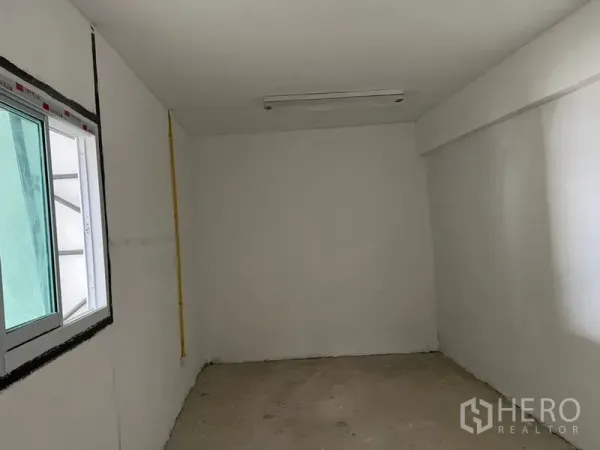 货栈 出租在Suan Luang, Bangkok - 仓库内的小型办公室，带推拉窗、白色墙面与顶灯。