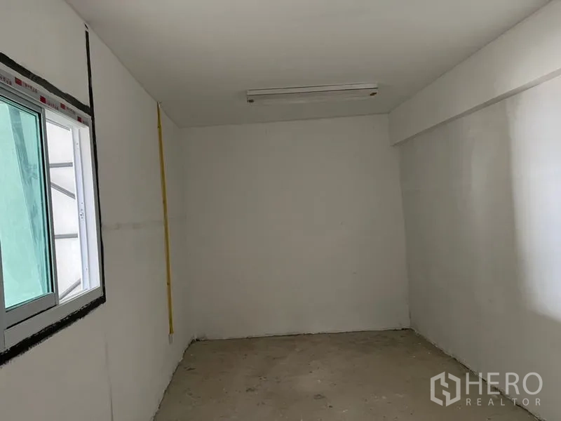 货栈 出租在Suan Luang, Bangkok - 仓库内的小型办公室，带推拉窗、白色墙面与顶灯。