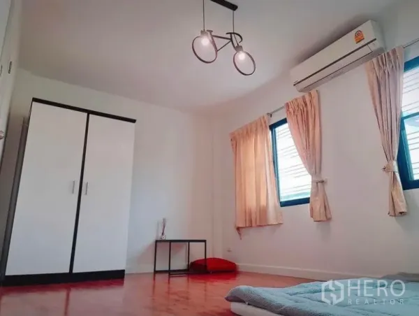 Townhouse for rent in Suan Luang, Bangkok - Bright bedroom with wood flooring, wardrobe, two windows, AC and pendant light