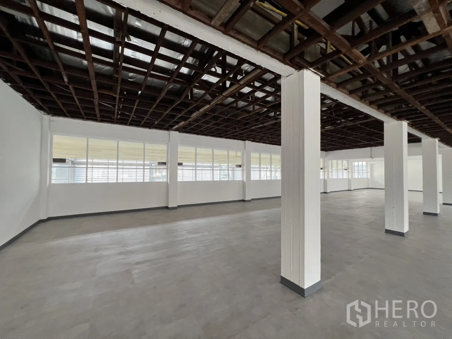 Office Space for rent in Watthana, Bangkok - Corner of the office showing rows of windows and structural columns for easy layout zoning.