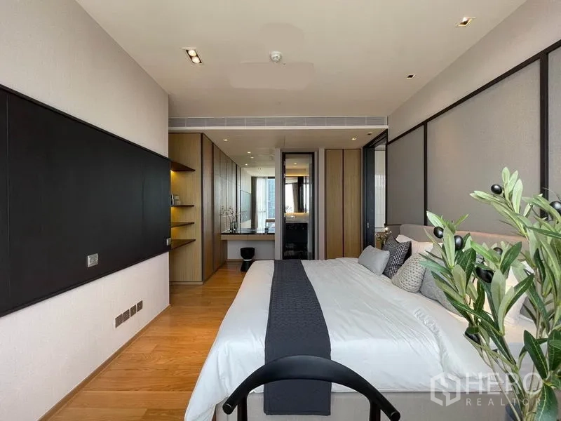 Condominium for rent in Khlong Toei, Bangkok - Spacious bedroom with king bed, work desk, wood flooring and sliding doors to the living area.